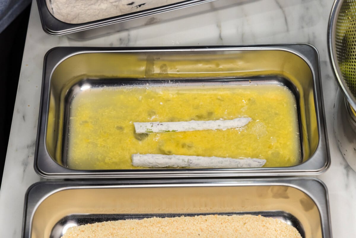 dipping asparagus spears into egg