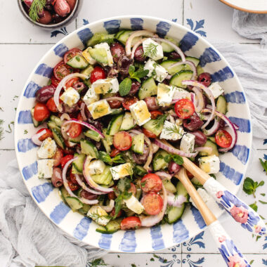 Bowl of Greek Salad with serving spoons in it
