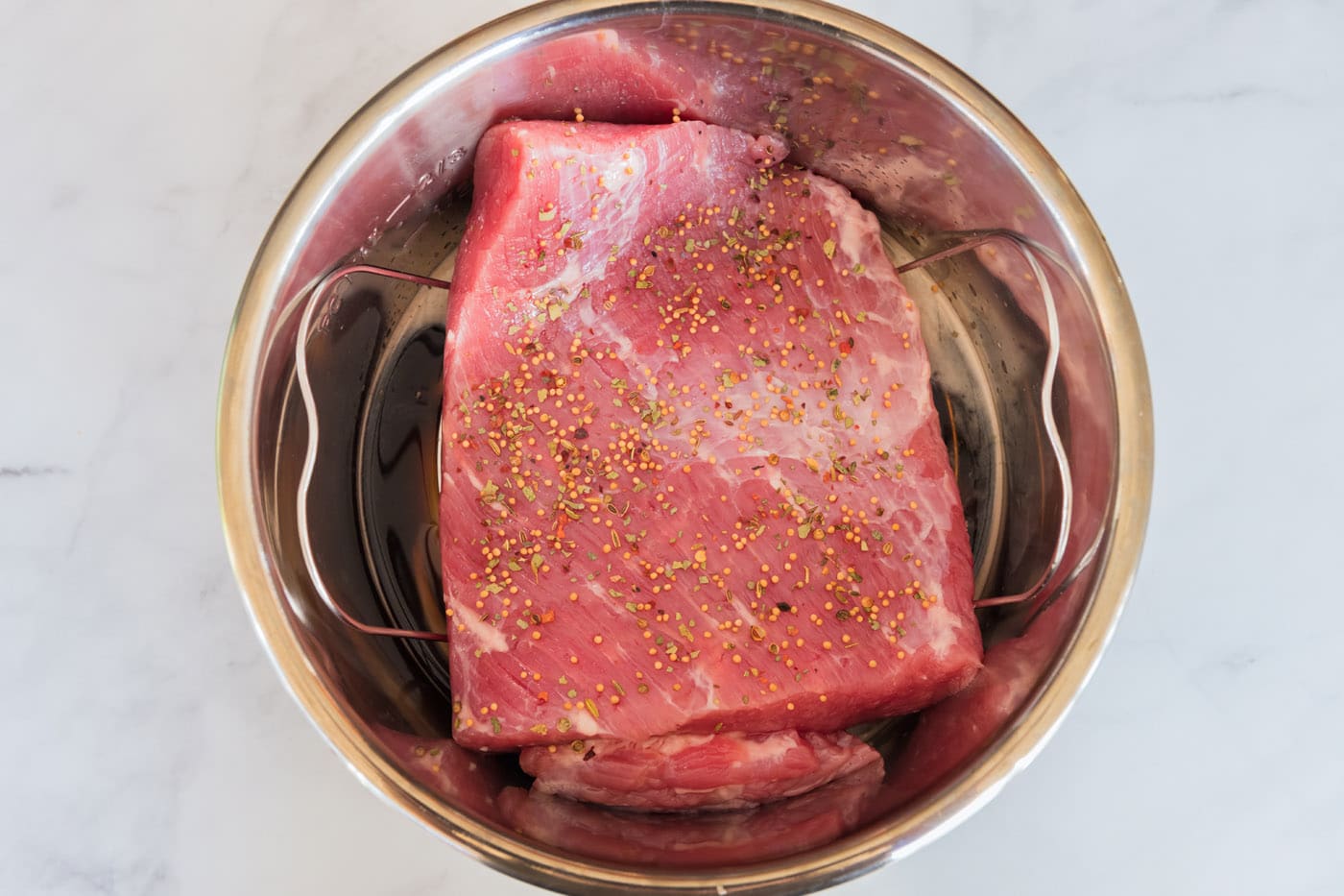 Corned beef in an Instant Pot topped with seasoning