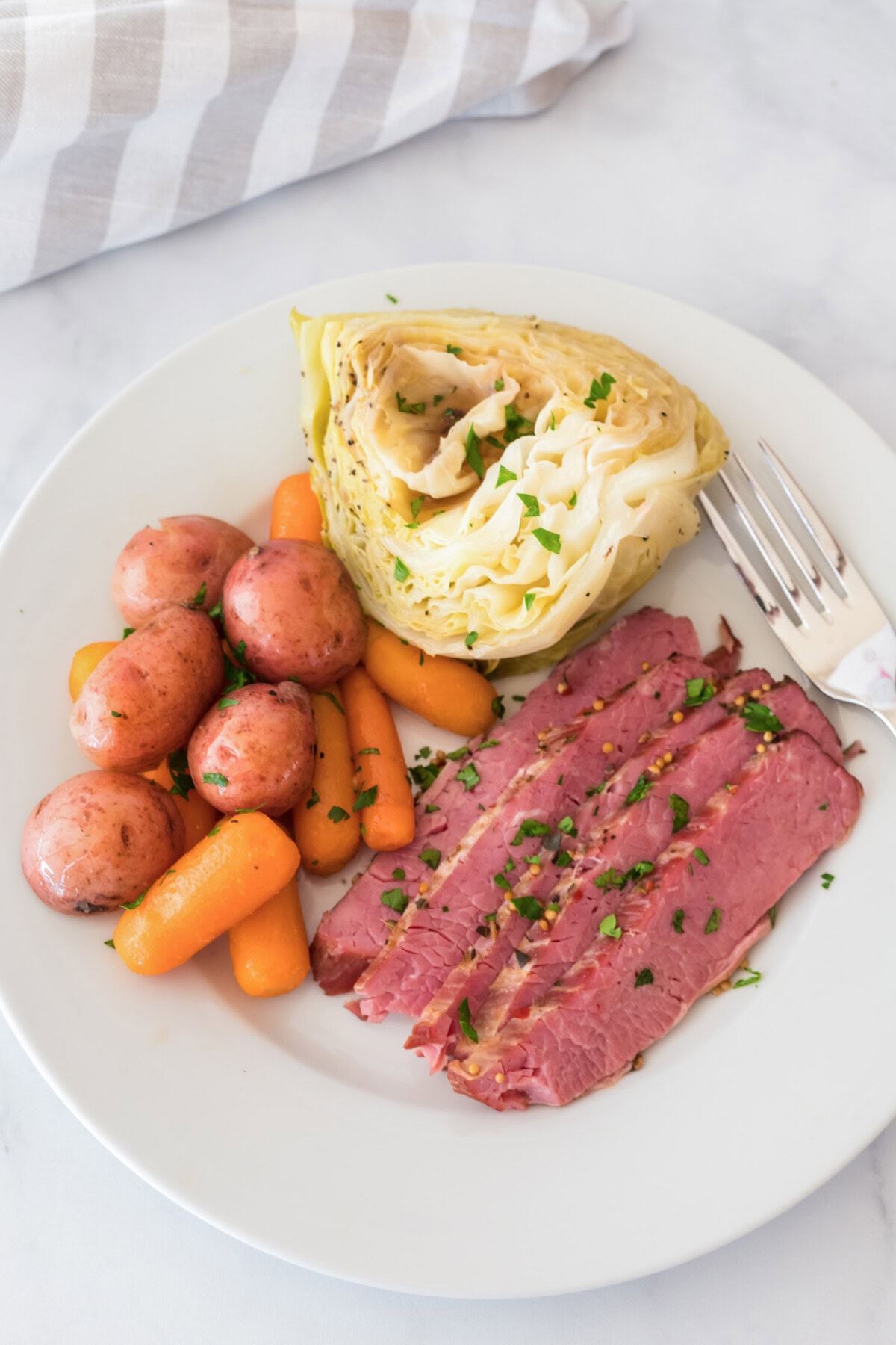 Instant Pot Corned Beef on a plate with cabbage, carrots and potatoes
