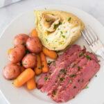 Instant Pot Corned Beef on a plate with cabbage, carrots and potatoes