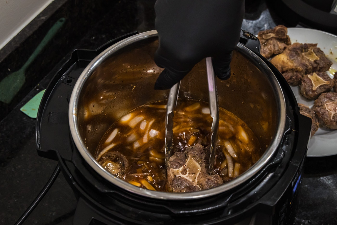 adding oxtail to sauce mixture in instant pot