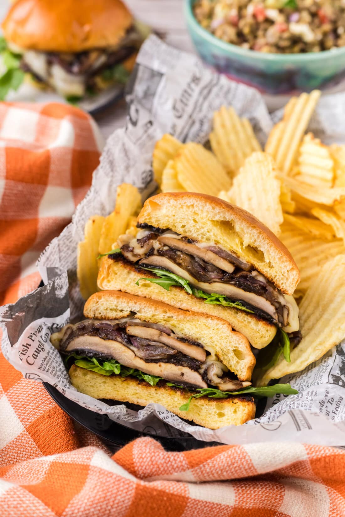 Mushroom Burger cut in half in a basket with chips