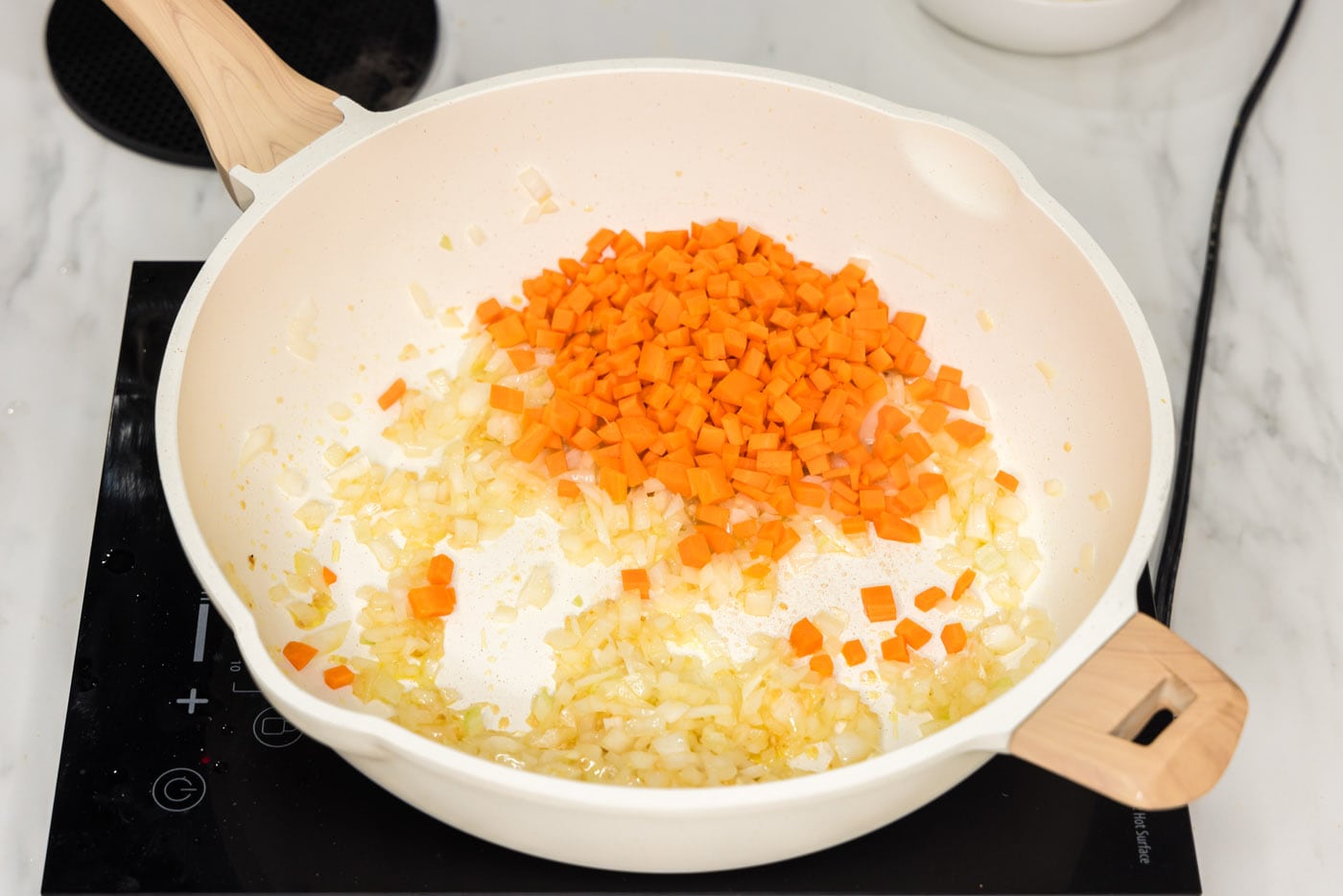 diced carrots added to skillet with onion, garlic, and ginger