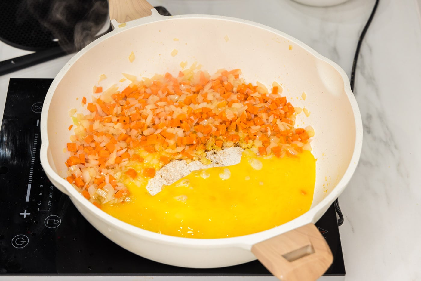 adding whisked eggs to stir fry veggies in skillet