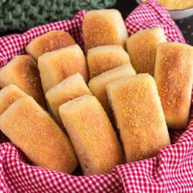 Close up photo of Pull Apart Cornmeal Dinner Rolls in a towel lined basket