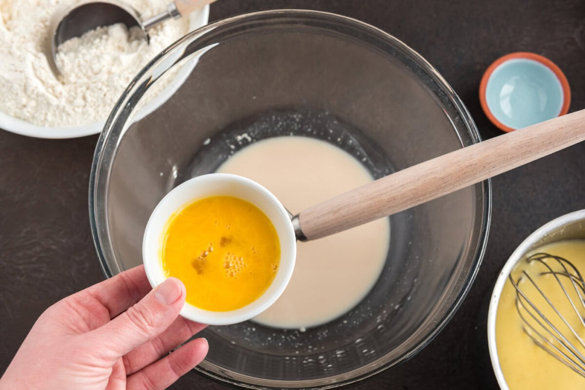 adding egg to dissolved active yeast in a bowl