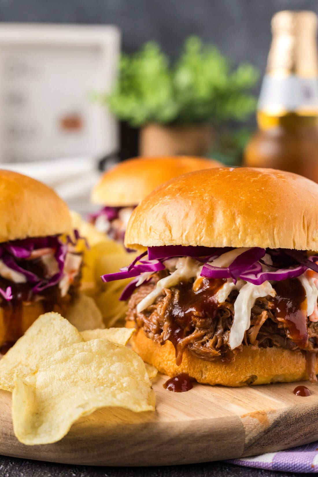 Close up photo of a Pulled Pork Sandwich with chips on the side