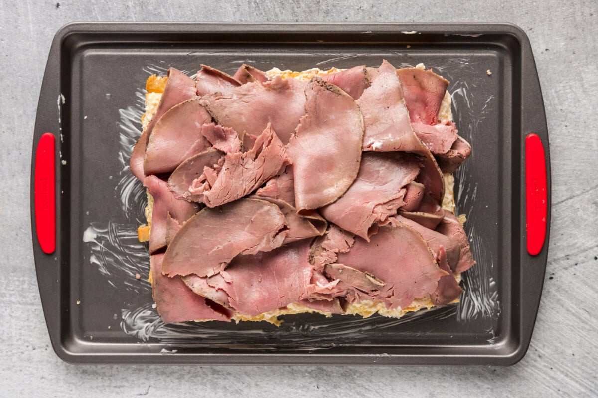 sliced deli roast beef on top of slider buns