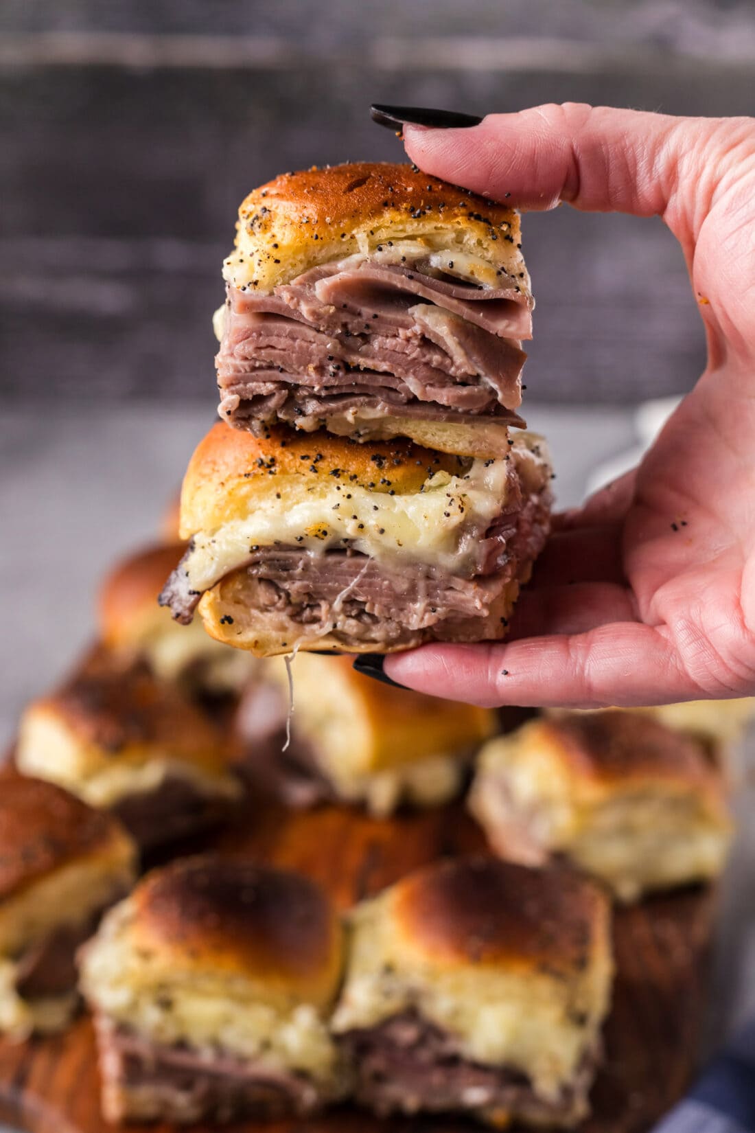 Hand holding up two Roast Beef Sliders