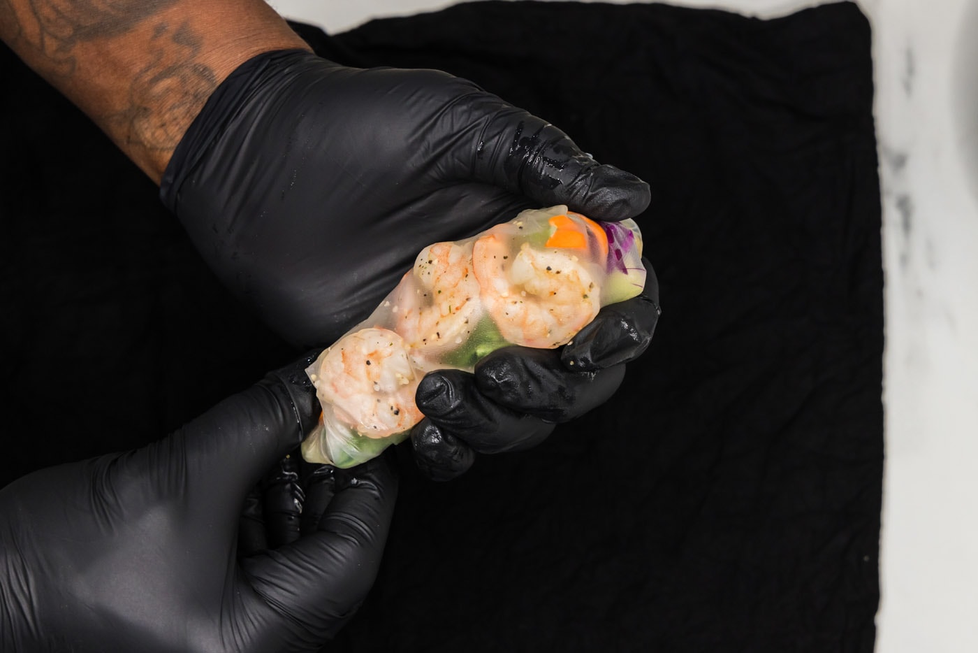 securing ends of spring rolls wrappers with shrimp and vegetables