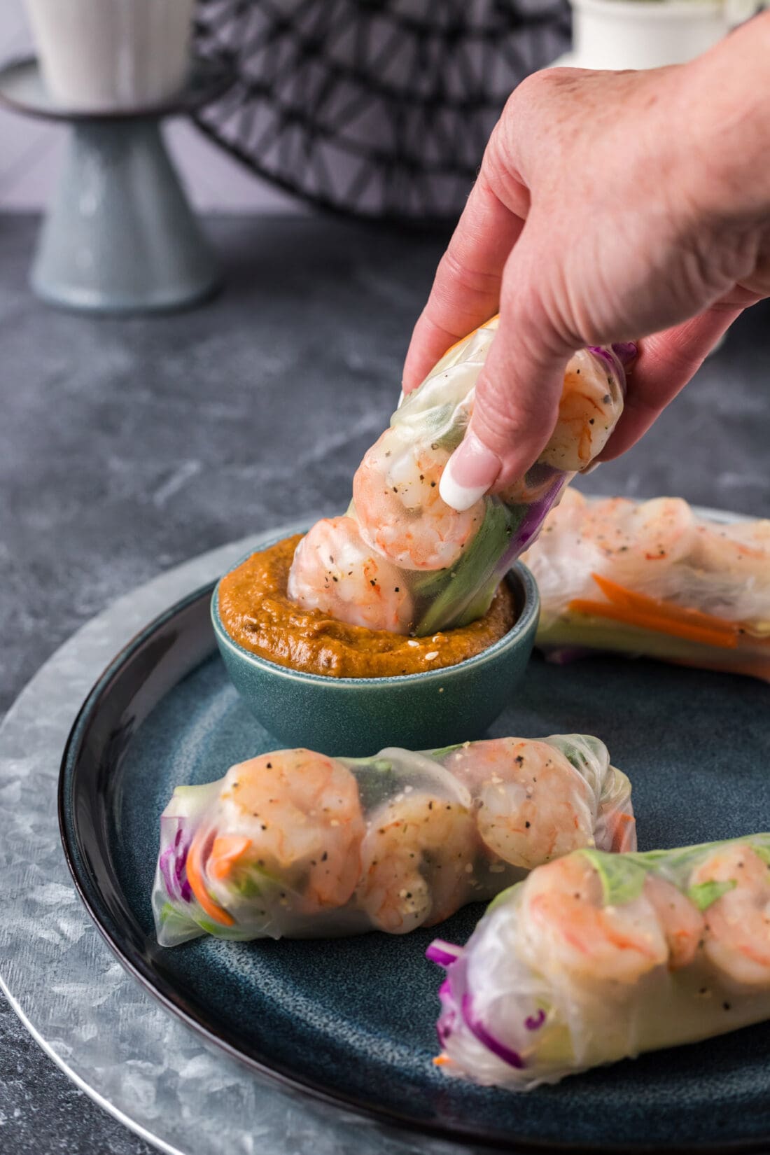 Shrimp Spring Roll being dipped into a a bowl of sauce