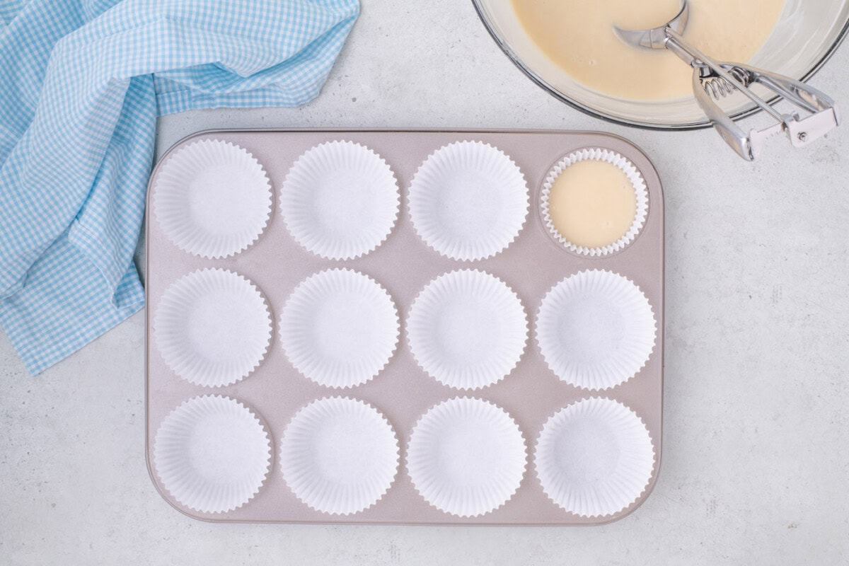 filling cupcake liners with vanilla cupcake batter