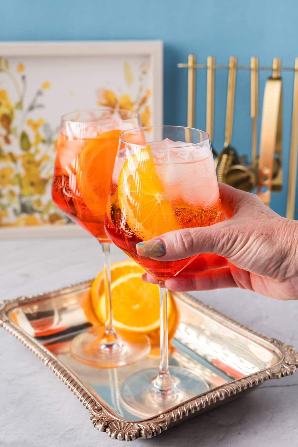 Hand grabbing a Aperol Spritz