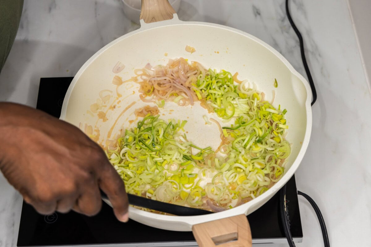 sauteeing leeks in a skillet with shallots and garlic