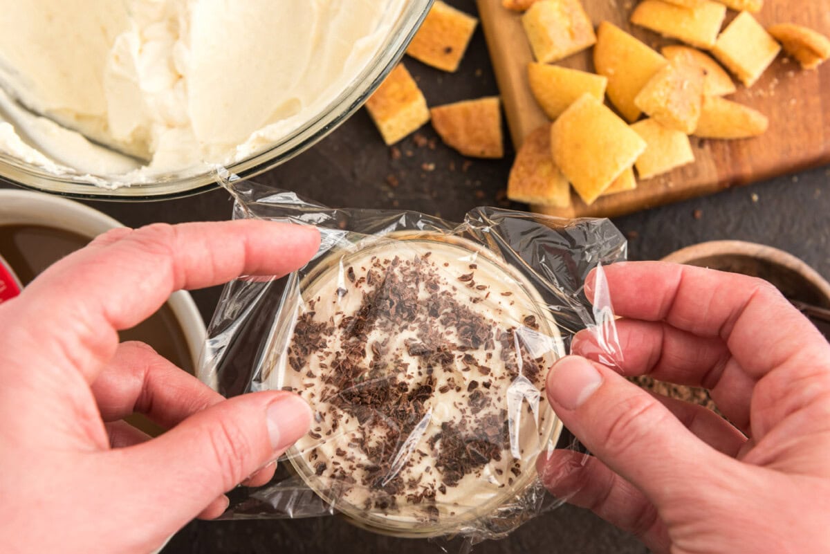covering Bailey's tiramisu parfaits with plastic wrap