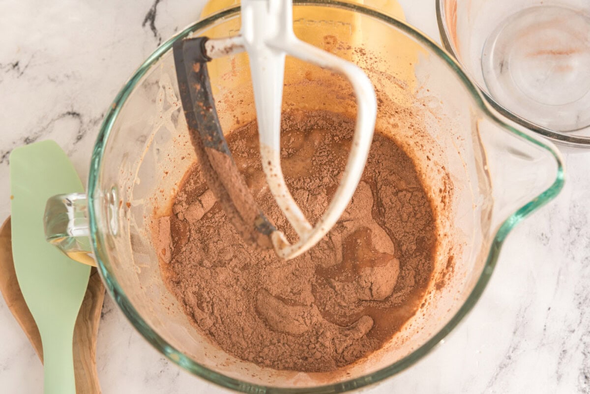 adding dry ingredients to wet ingredients in a mixer