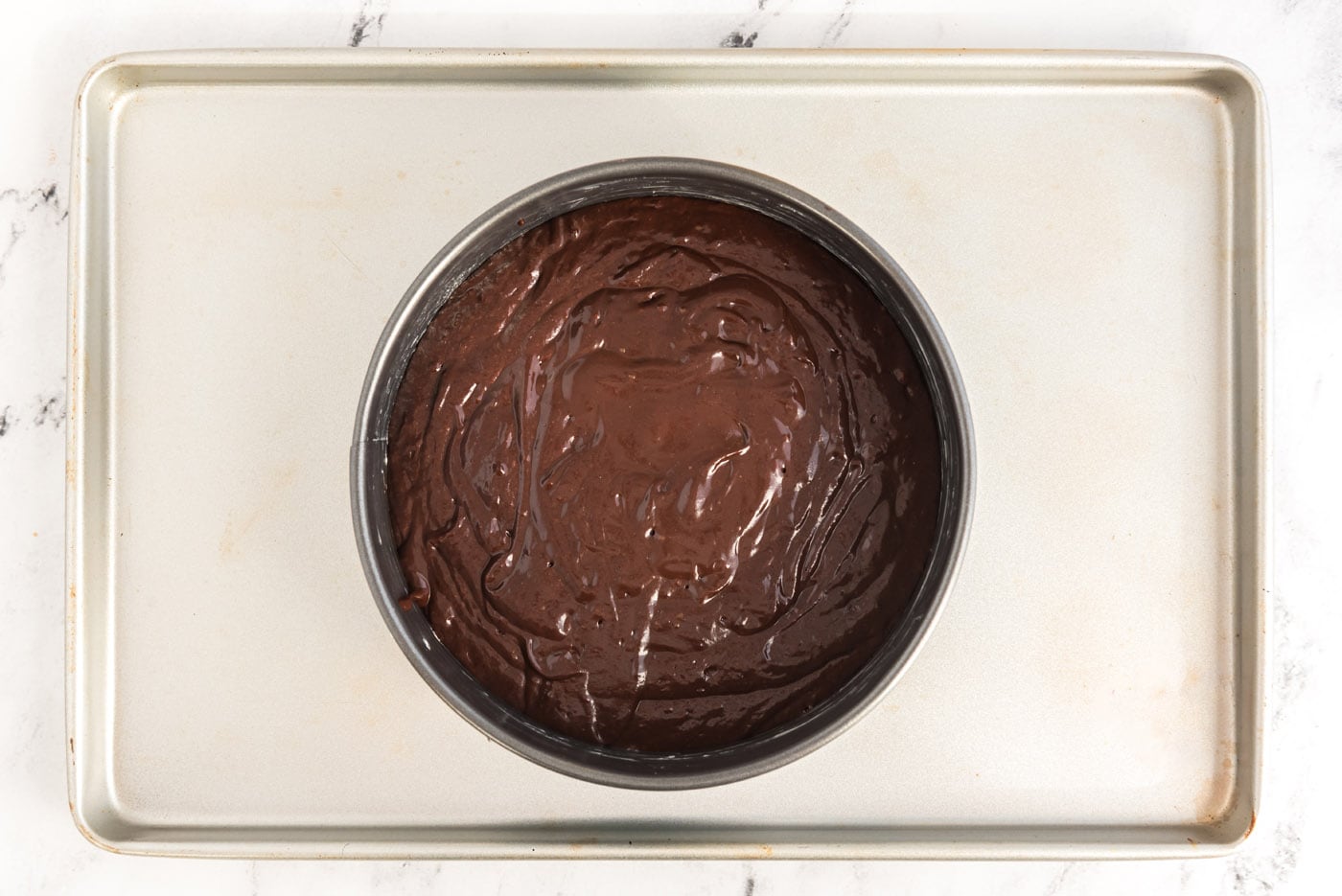 dark chocolate cake batter in a springform pan