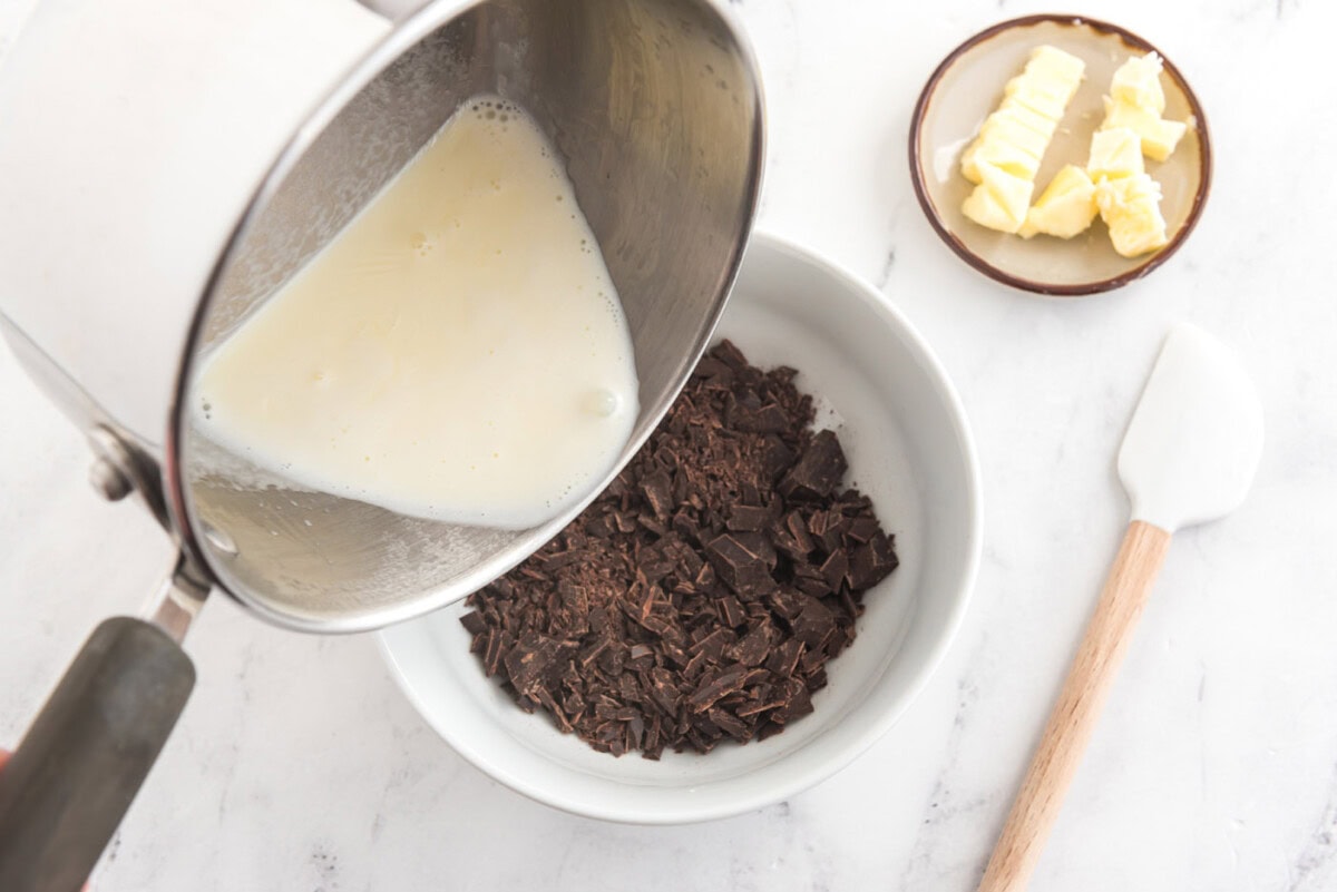 pouring heavy whipping cream into chocolate