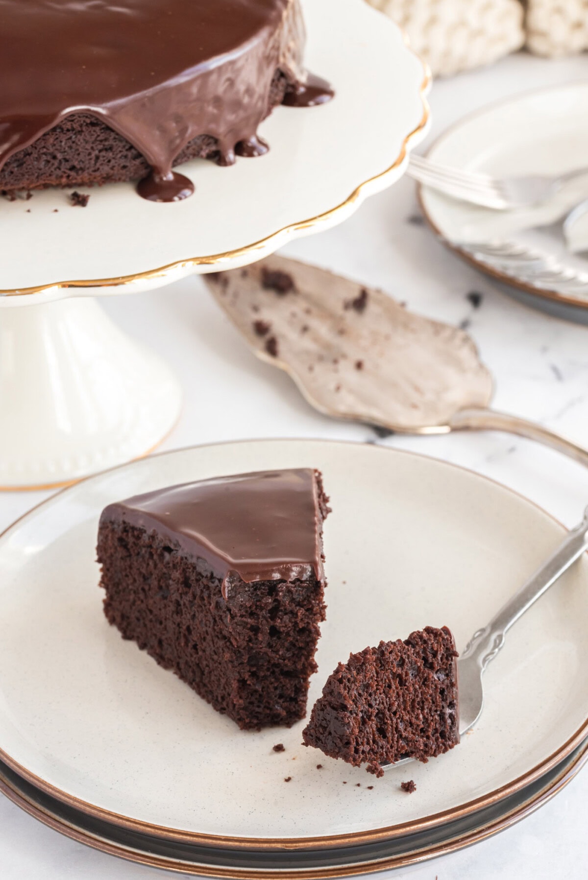 Slice of Dark Chocolate Cake on a plate with a bite removed