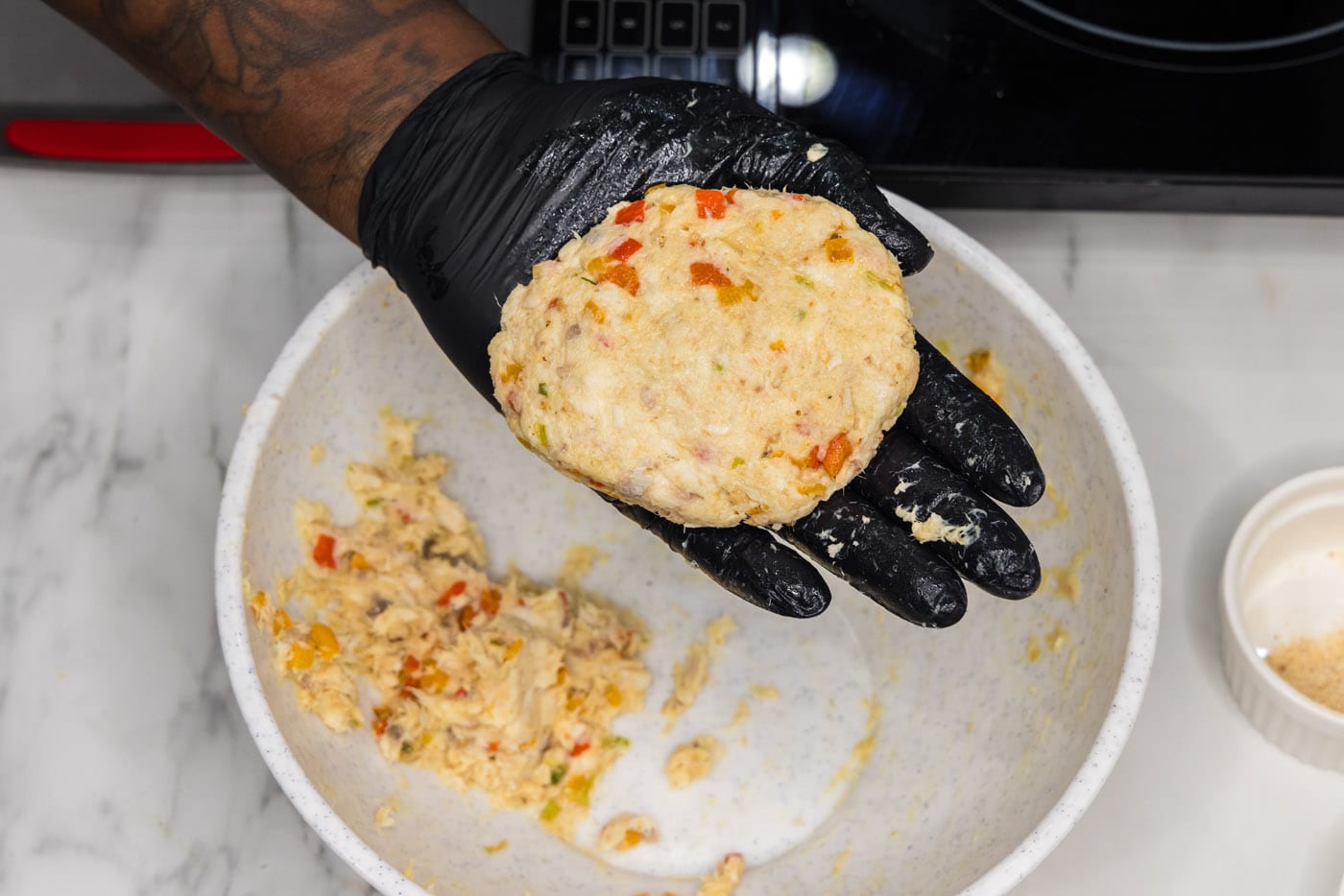 forming fish mixture into a patty with gloved hands