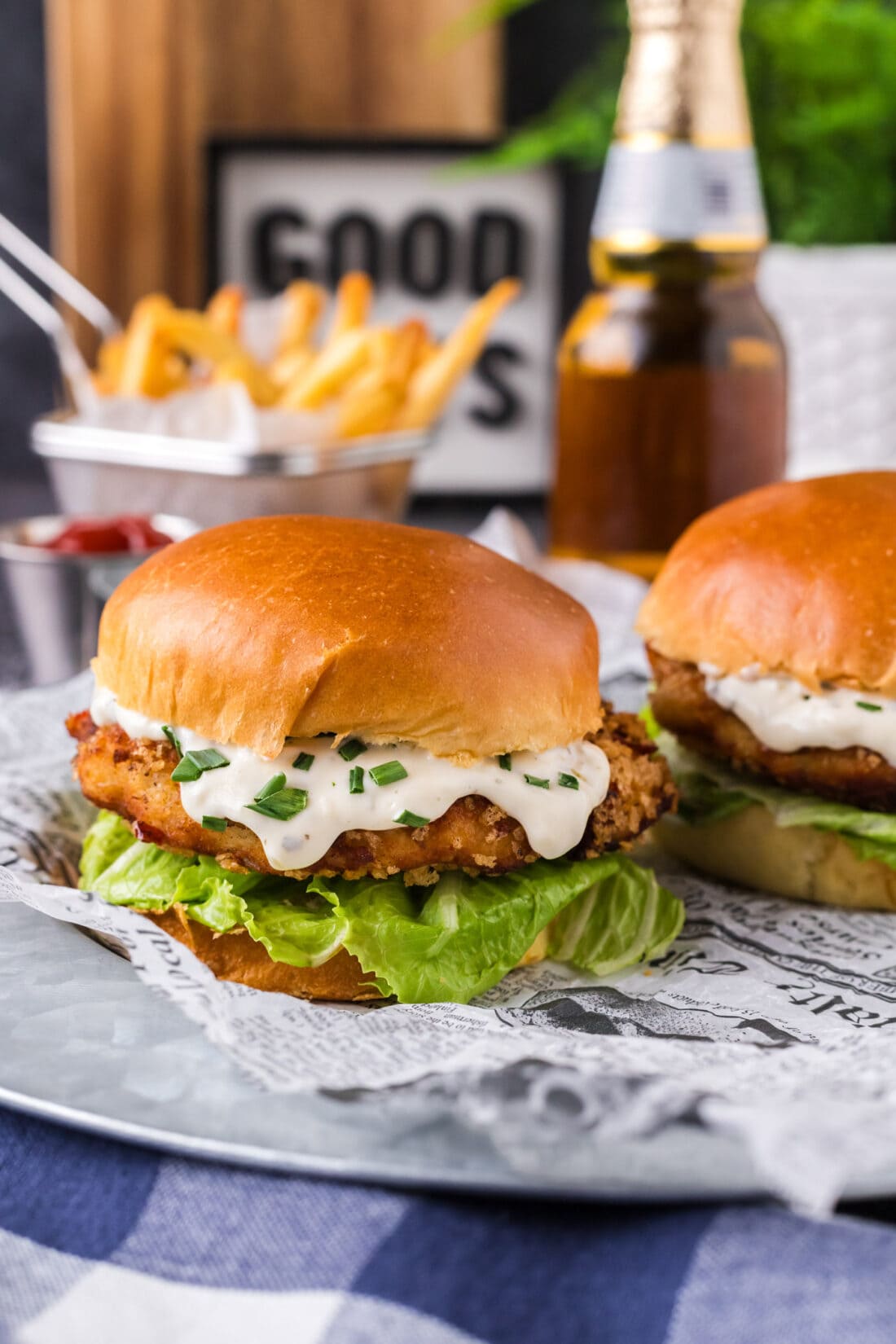 Two Fish Burgers on a platter with fries in the background