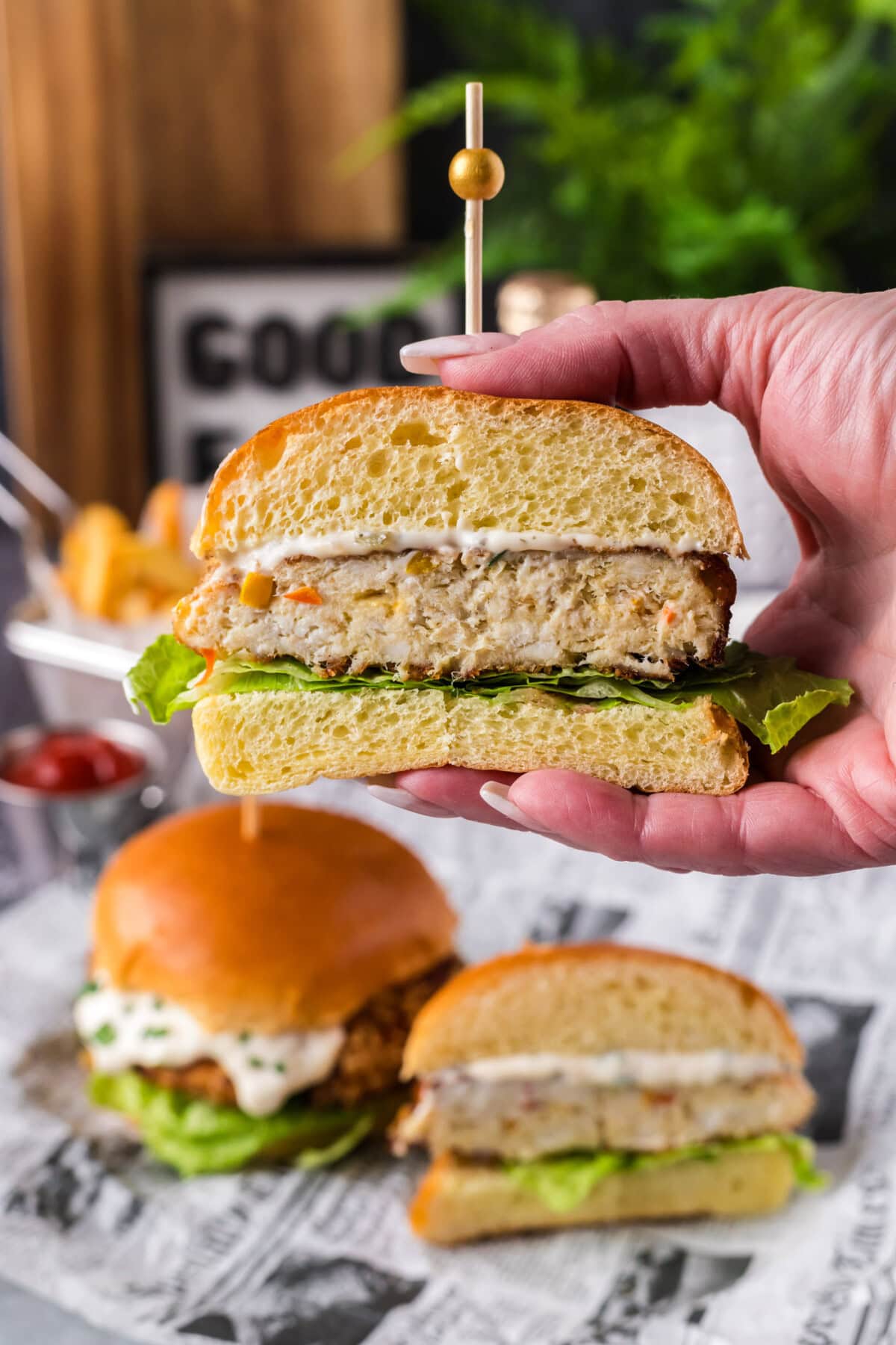 Hand holding up a Fish Burger cut in half