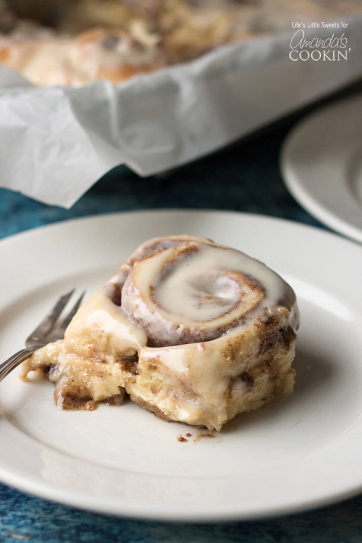These Homemade Cinnamon Rolls are a true classic. Topped with cream cheese frosting, these gooey cinnamon rolls satisfy your sweet craving! They also make the perfect holiday morning breakfast with the family. #breakfast #cinnamonrolls #breadrecipes #holidaybreakfast #dough #cinnamon Homemade Cinnamon Roll on a plate