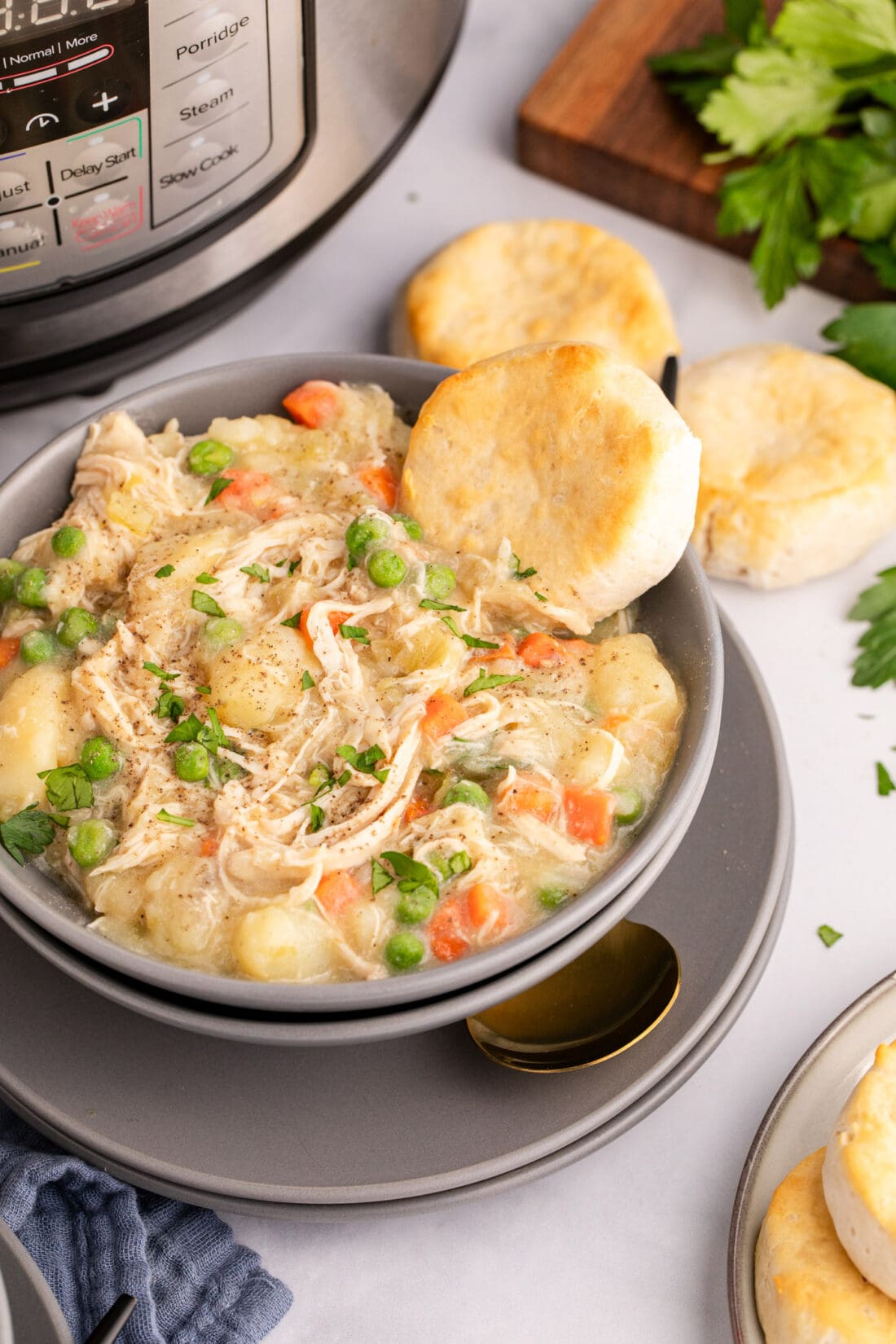 Bowl of Instant Pot Chicken Pot Pie with biscuits on the side