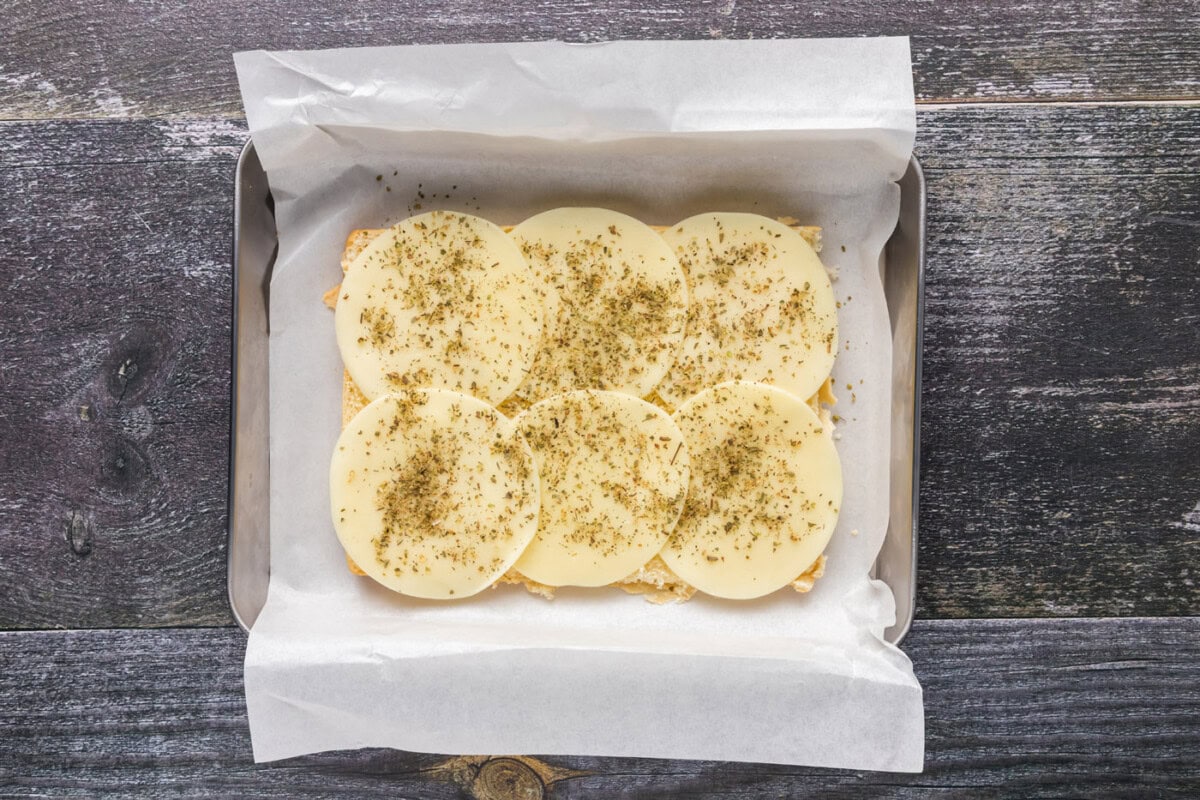 provolone cheese with italian seasoning on top of slider buns