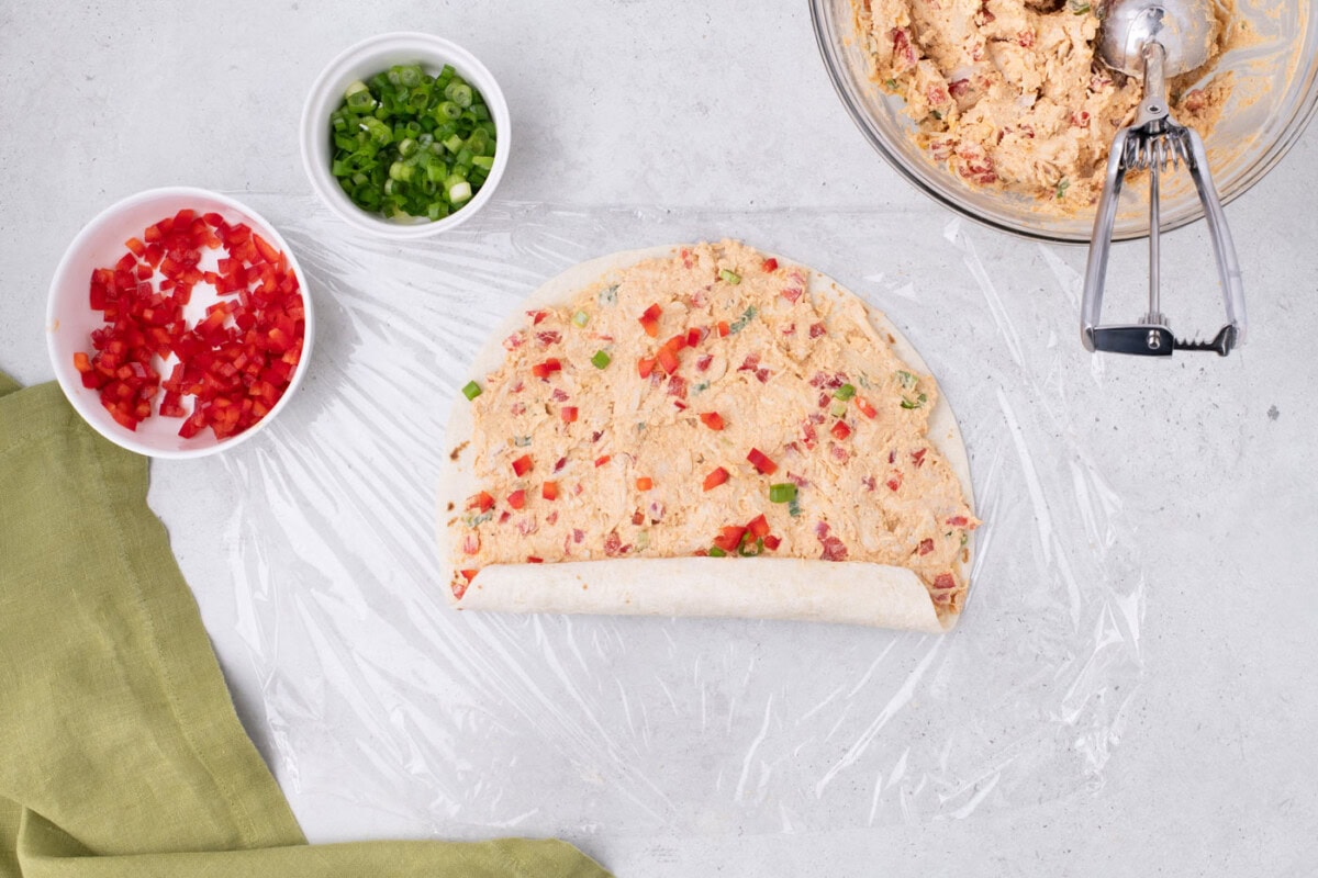 rolling burrito wrap up with cream cheese and chicken mixture