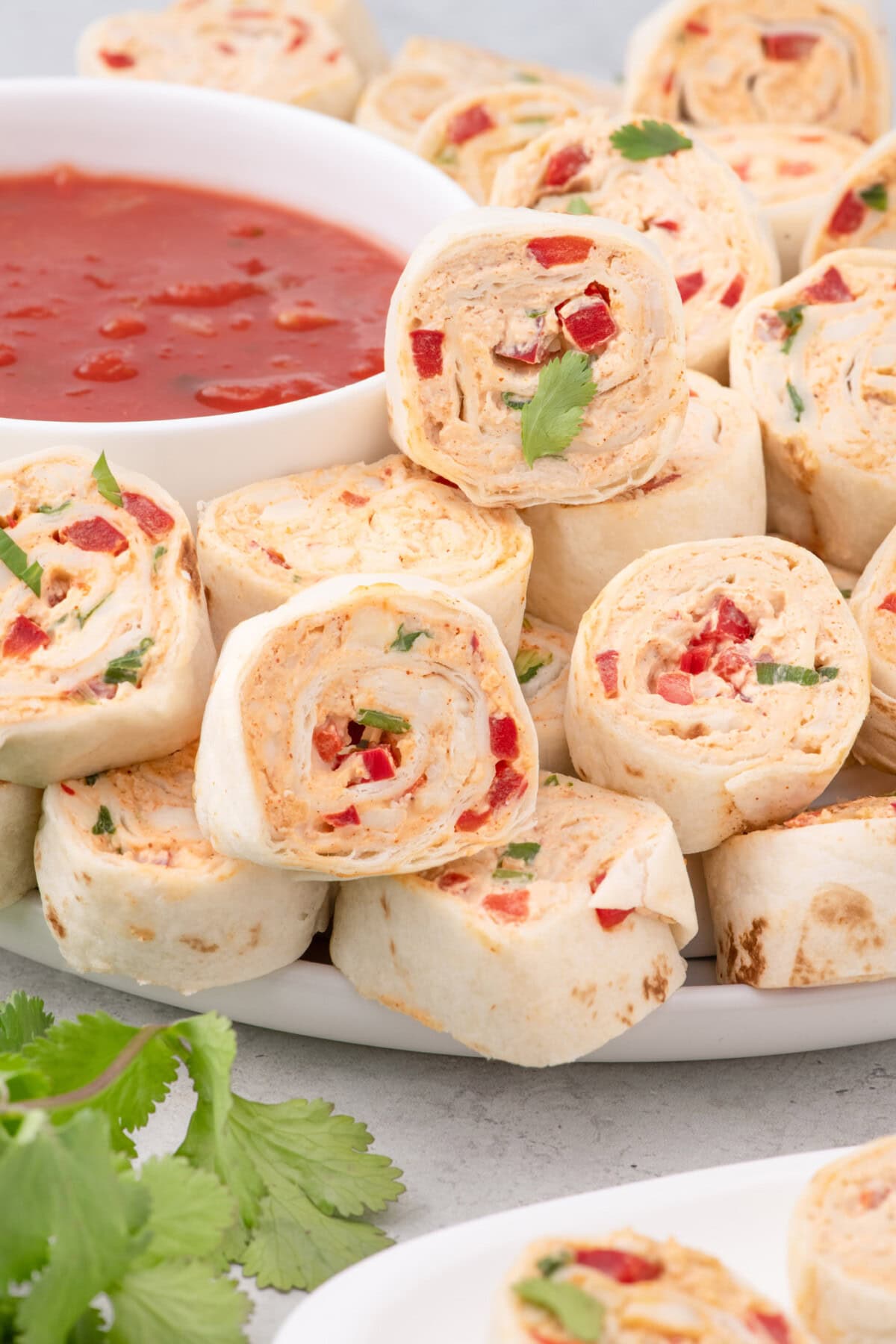 Mexican Pinwheels on a plate with salsa in a bowl