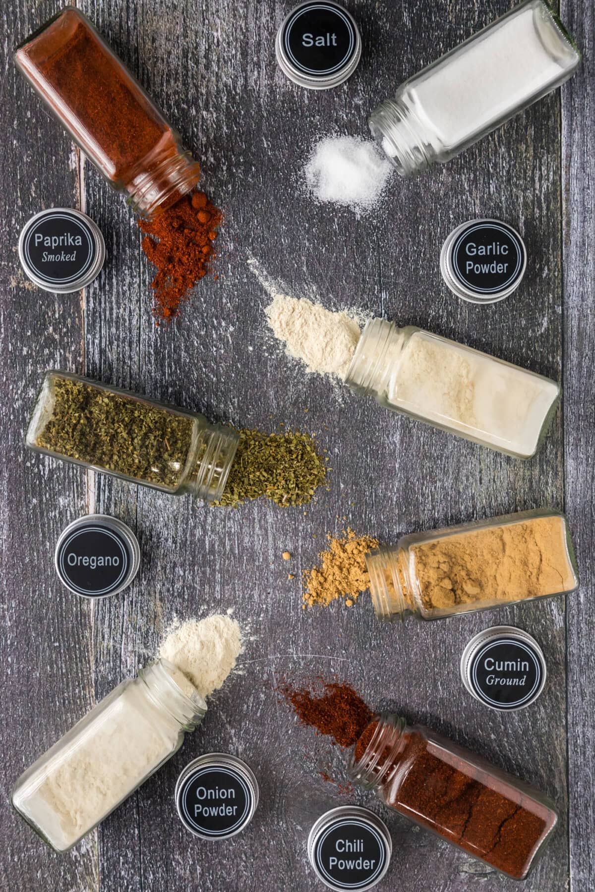 Spices jars needed for Mexican Seasoning spilled on a table
