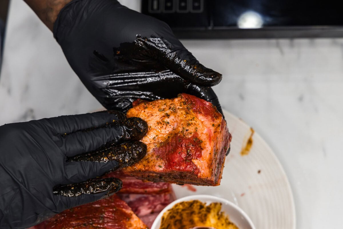 rubbing olive oil and seasoning on short ribs