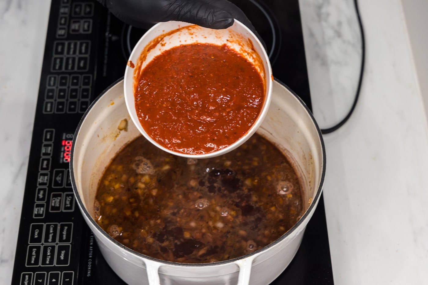 adding tomato and chipotle sauce into braising liquid