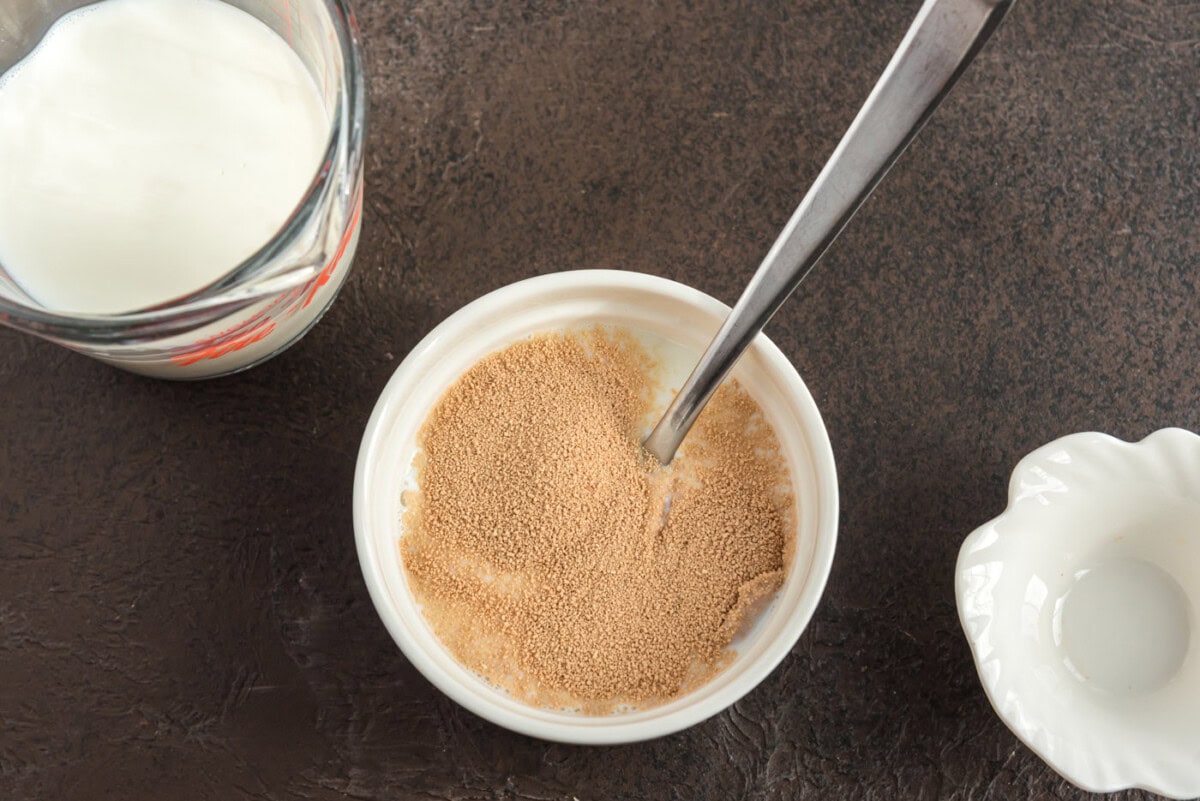 mixing active dry yeast with milk in a bowl