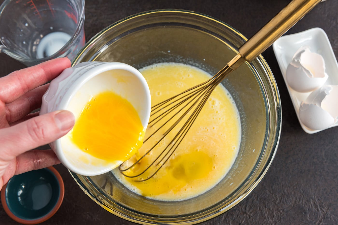 adding beaten egg to bowl of butter, milk, and sugar mixture