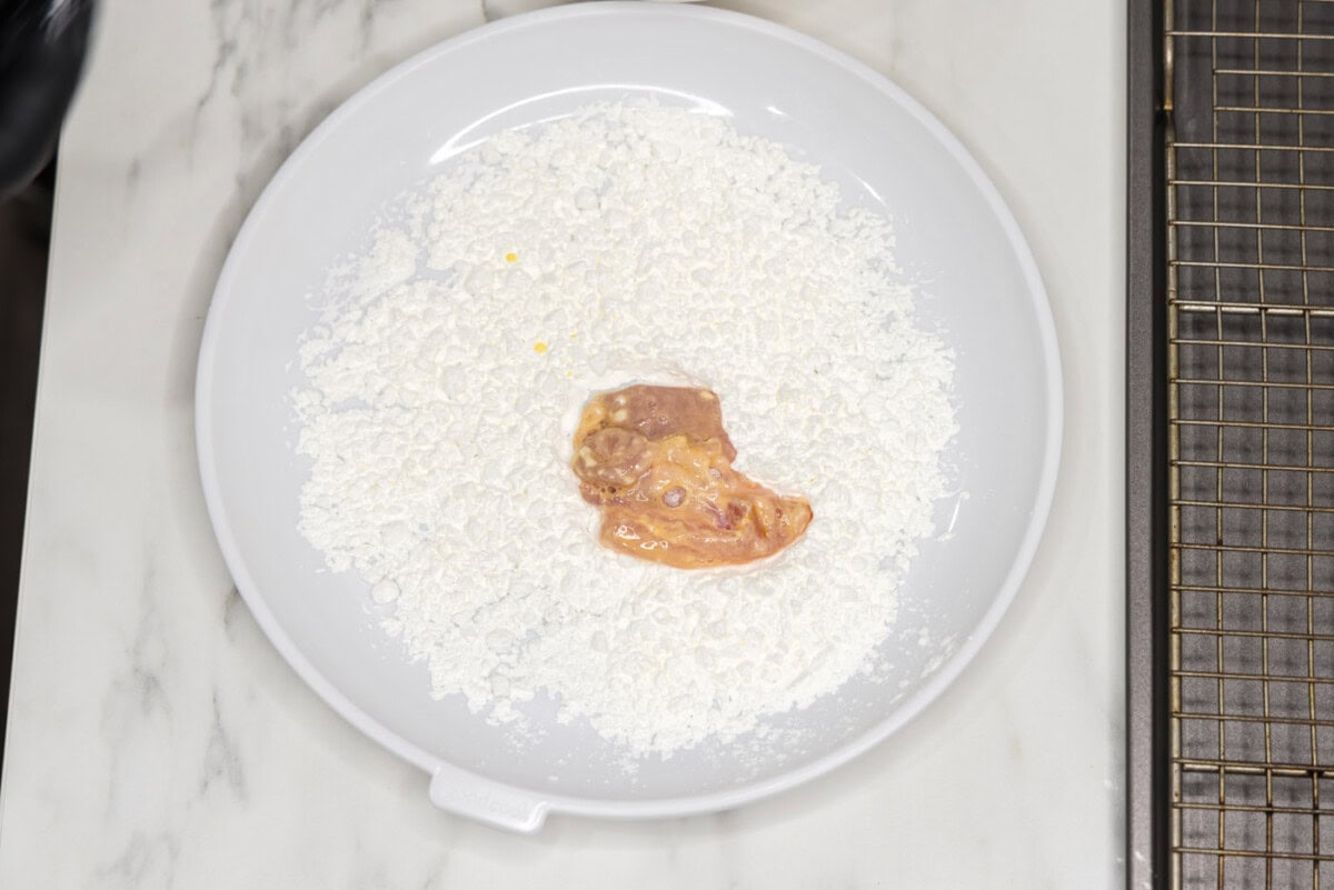coating chicken piece in cornstarch before frying