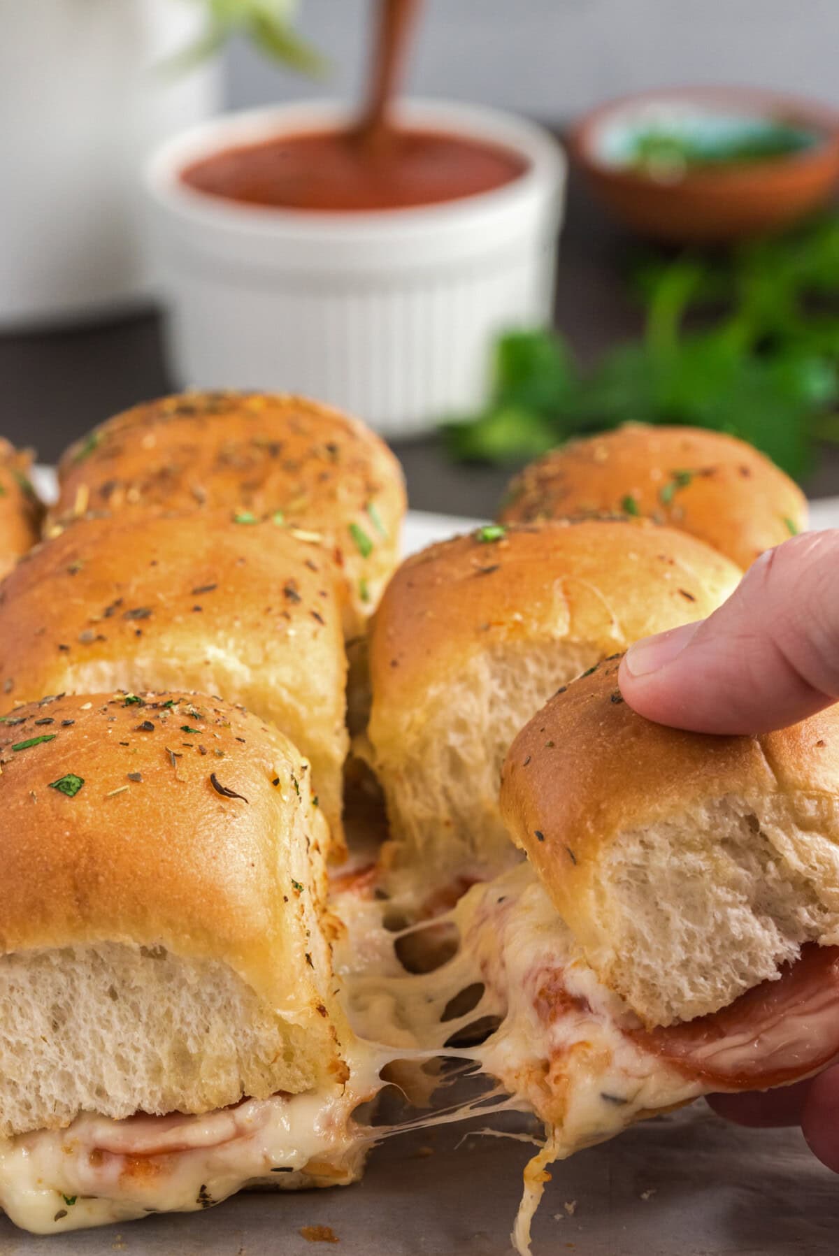 Hand pulling away a Pizza Slider from the rest