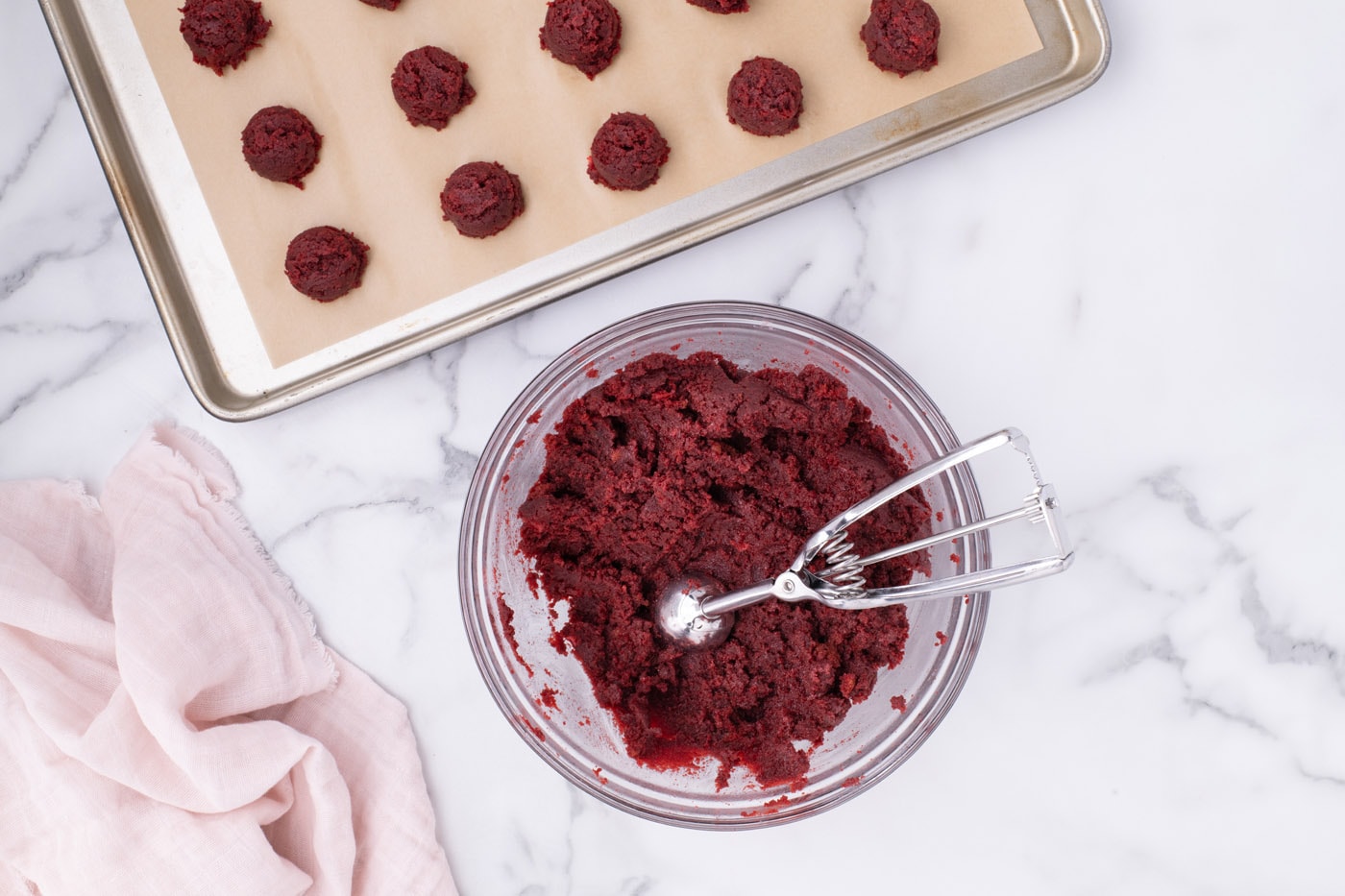cookie dough scoop in red velvet cake ball mixture