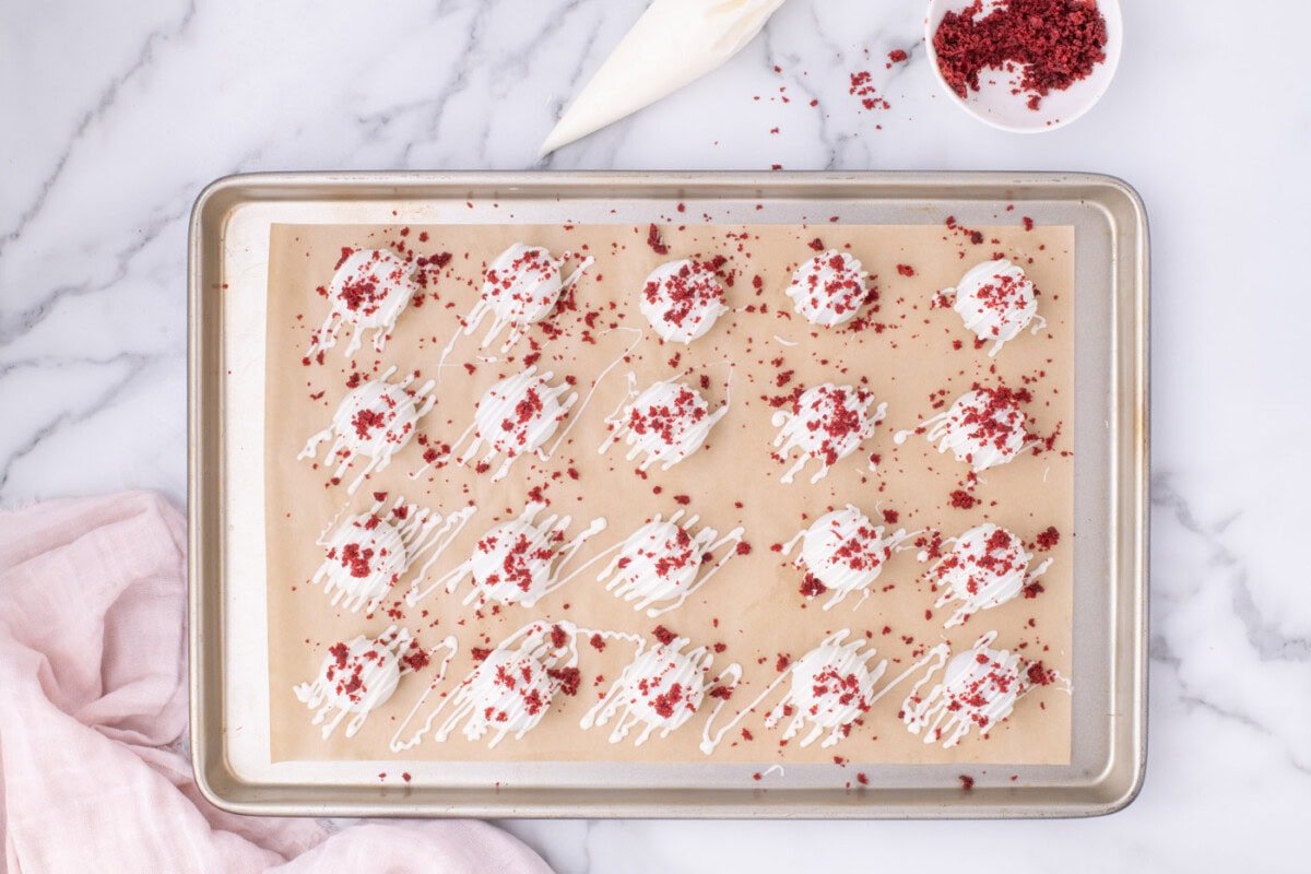 overhead of red velvet cake balls on a baking sheet