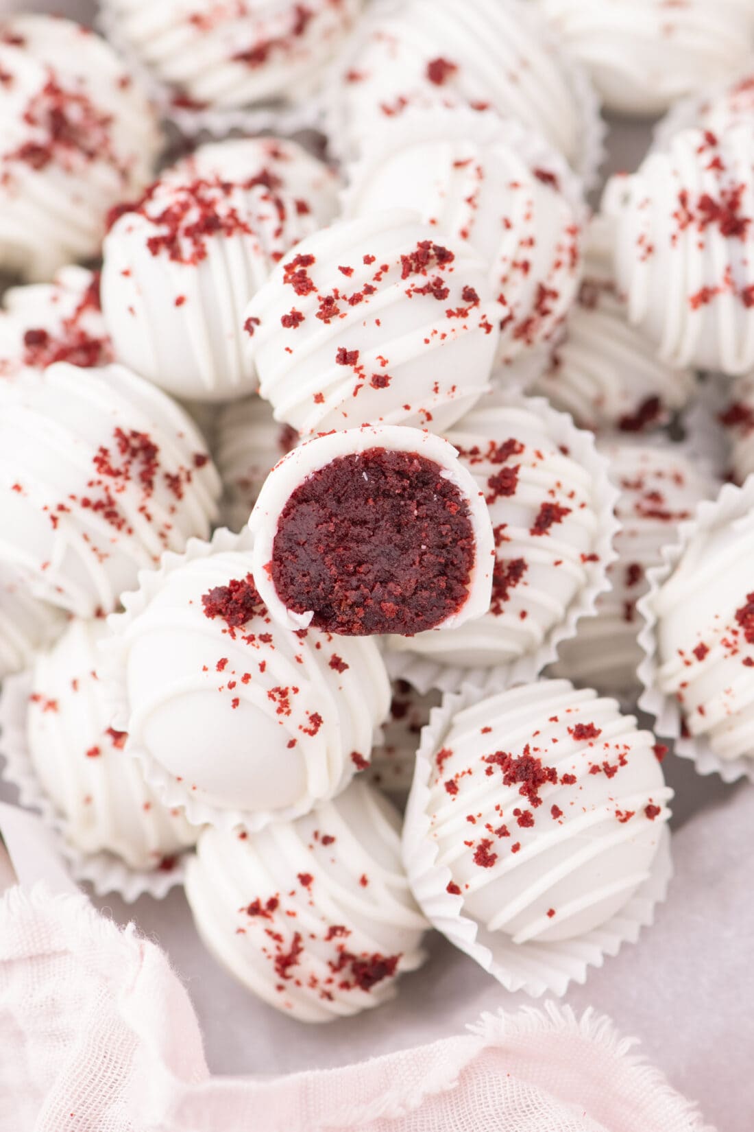 Red Velvet Cake Balls with one cut in half resting on top