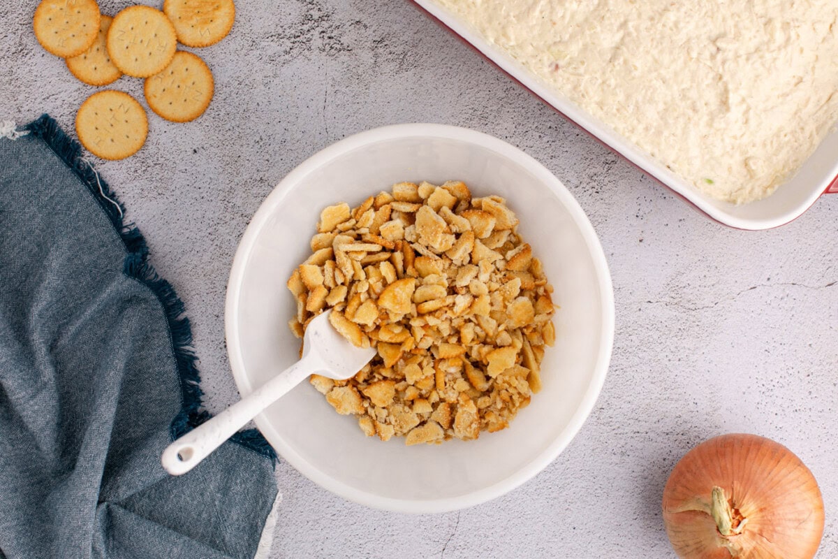 a bowl with crushed Ritz crackers and butter