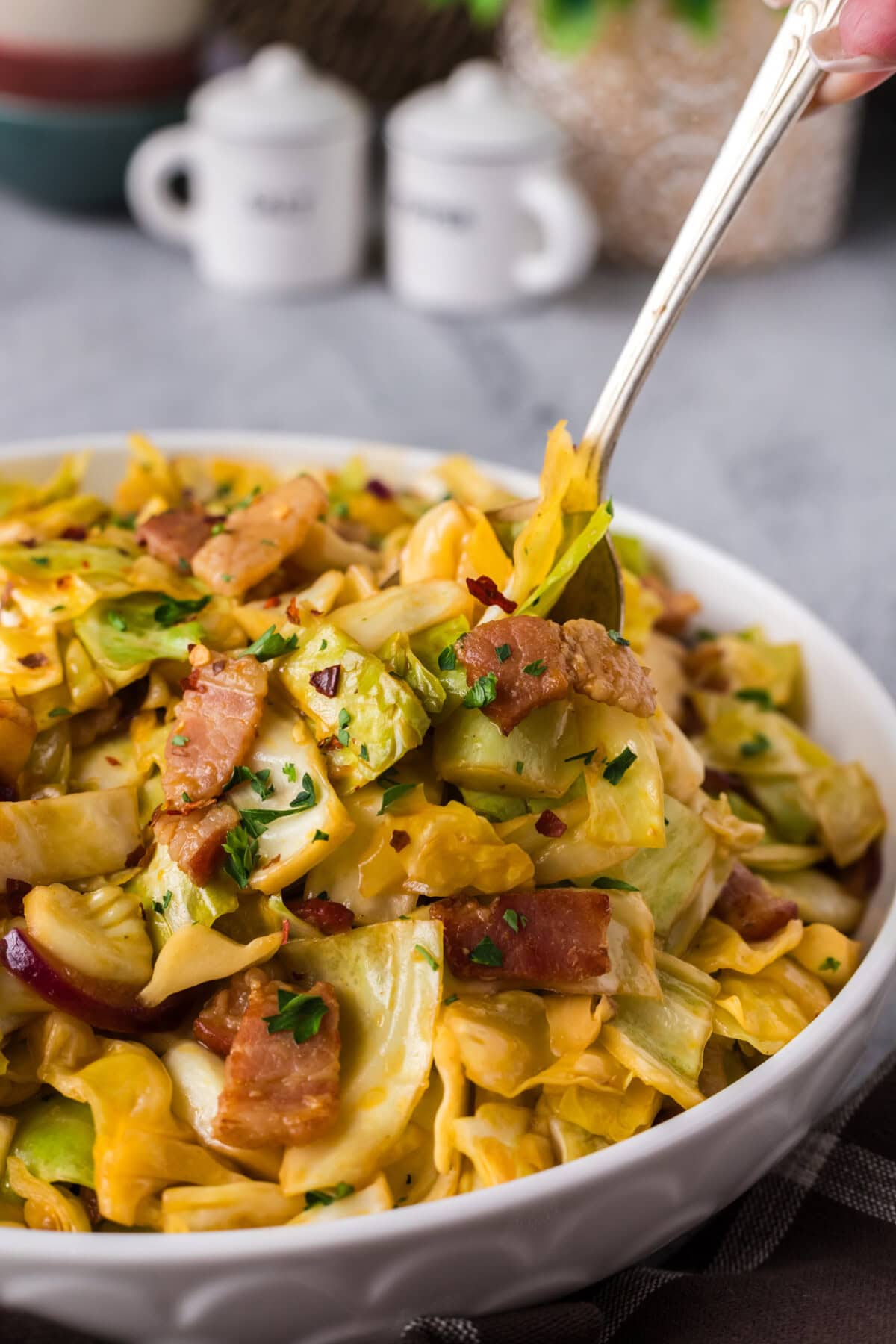 Spoon in a bowl of Spicy Fried Cabbage