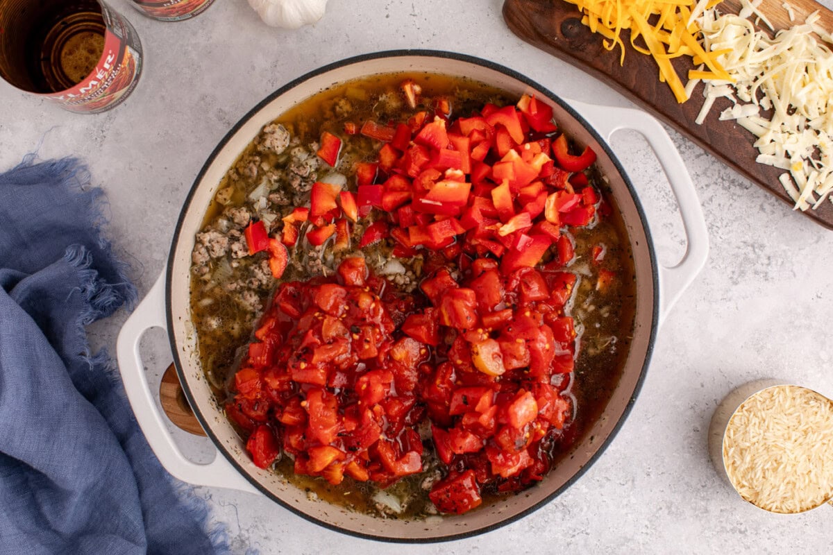 fire roasted tomatoes and bell peppers added to skillet with beef and sausage mixture