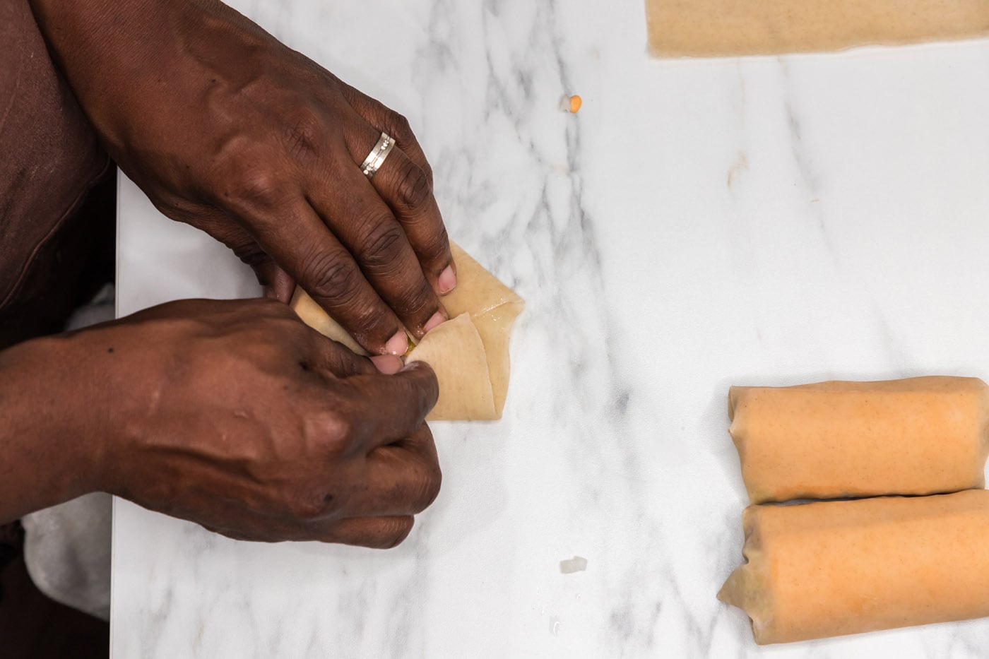 closing egg roll wrapper with hands