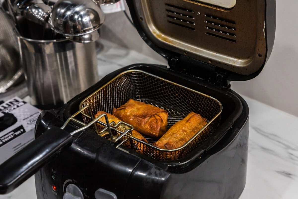 crispy egg rolls in a deep fryer basket