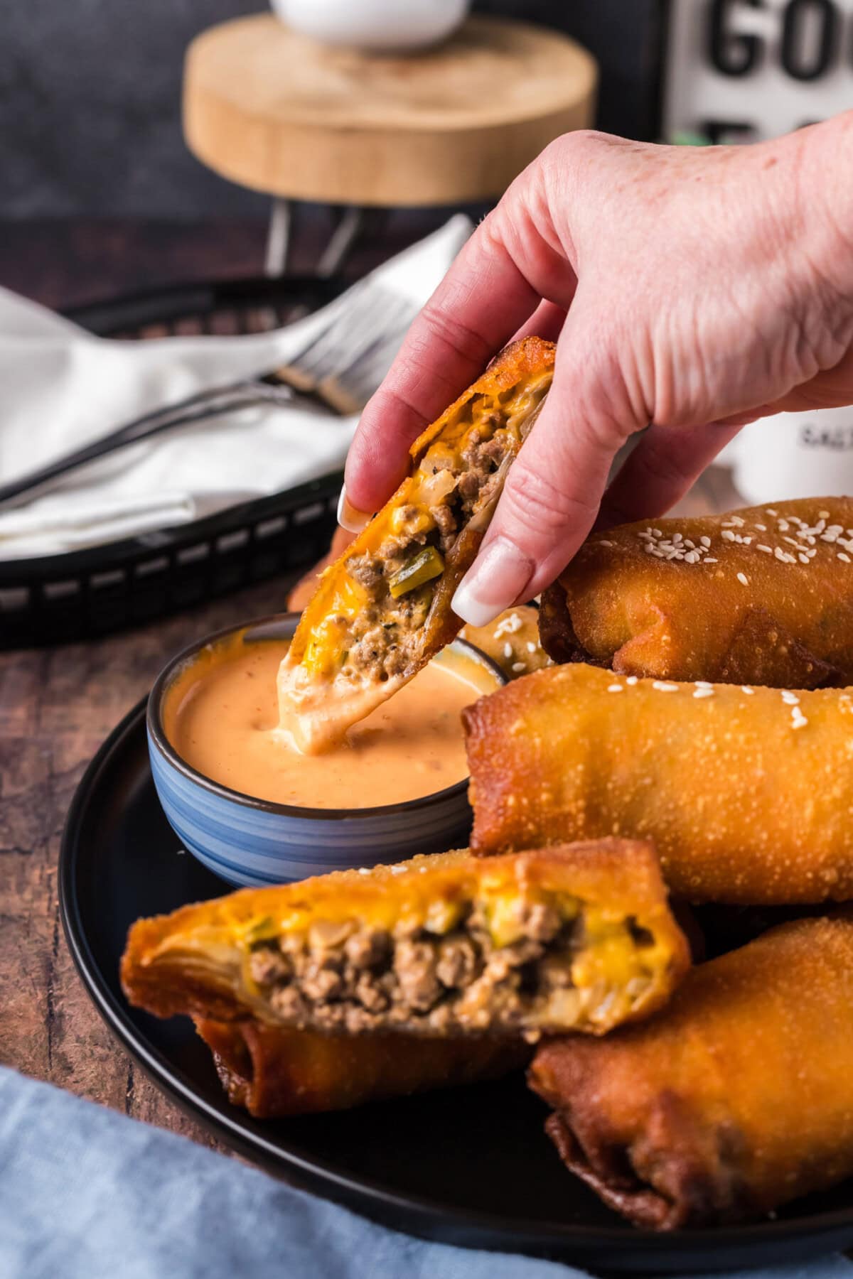 Half of a Big Mac Egg Roll being dipped in Thousand Island dressing