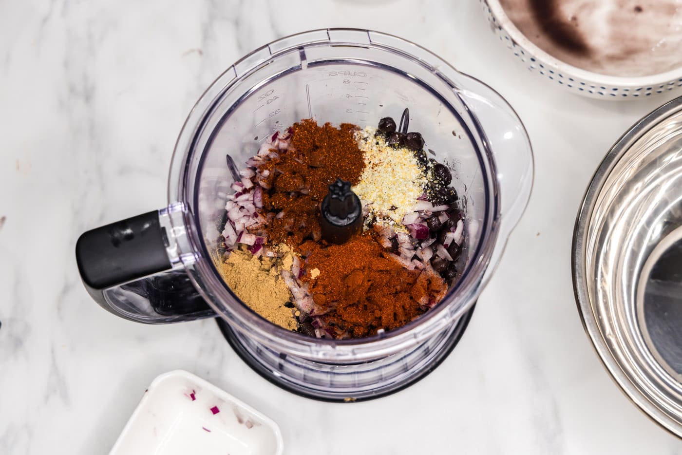 black beans with spices and seasonings in a food chopper