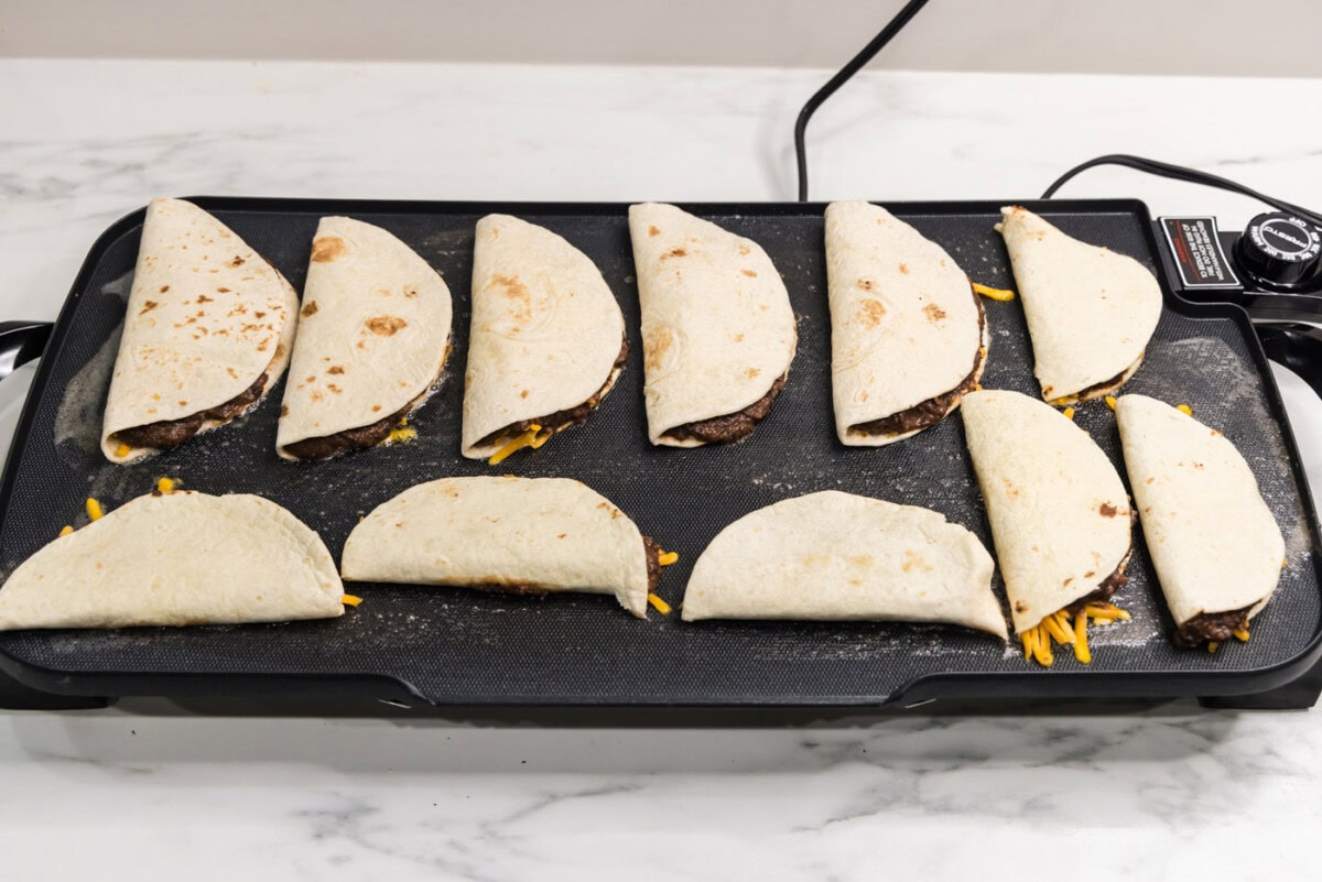 folded black bean tacos on a griddle